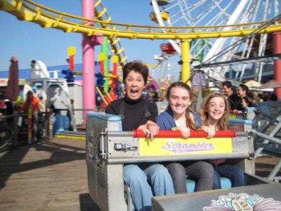 Three girls on a ferris wheel at the amusement park.