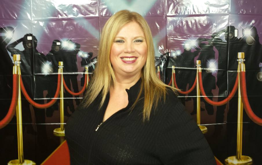 Vicki Wagner posing in front of a red carpet.