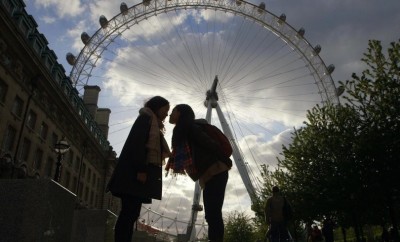 Two women kiss in front of the London Eye during the Asian Film Fest.