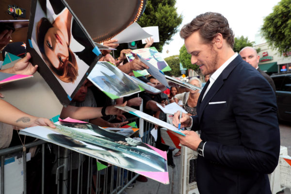 Sam Heughan signs autographs at the premiere. 
