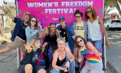 A group of people posing for a photo in front of the women's freedom festival.
